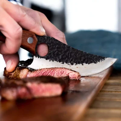 Huusk knife cutting meat on board - 02