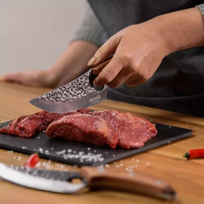 Huusk knife cutting meat on board